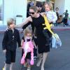 Angelina Jolie emmène trois de ses enfants faire du shopping pour Halloween le 28 octobre 2012 à Sherman Oaks en Californie dans le magasin Party City : elle porte dans ses bras son fils Knox, tandis que Shiloh, l'aînée, tient la main de la petite Vivienne