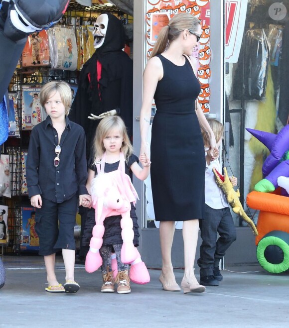 Angelina Jolie emmène trois de ses enfants faire du shopping pour Halloween le 28 octobre 2012 à Sherman Oaks en Californie dans le magasin Party City : elle porte dans ses bras son fils Knox