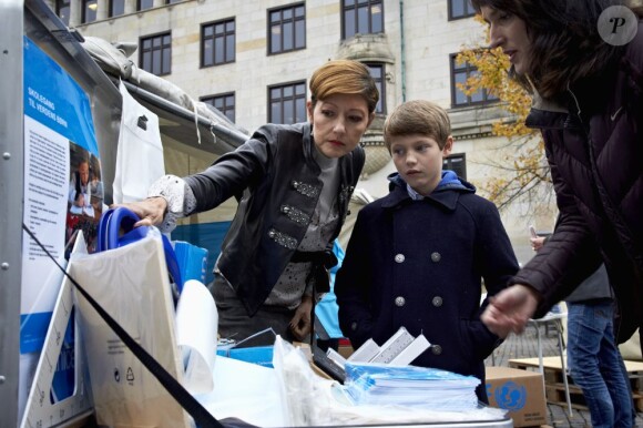 Felix de Danemark, 10 ans, et sa mère la comtesse Alexandra de Frederiksborg sur la place du Nytorv à Copenhague le 23 octobre 2012 pour découvrir l'expo photo Children's struggle for life de Jan Grarup.