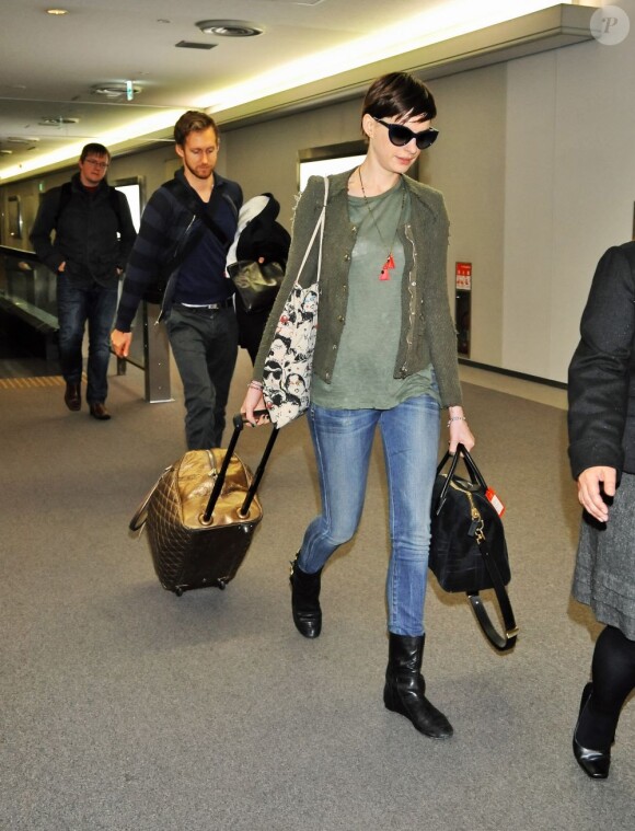 Anne Hathaway et son compagnon Adam Shulman arrivent à l'aéroport Narita de Chiba, le 26 novembre 2012.