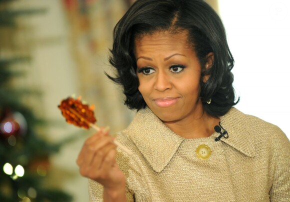 Michelle Obama, une sucrerie à la main, a dévoilé les décorations de Noël de la Maison Blanche en présence d'enfants de militaires, le 28 novembre 2012 à Washington.