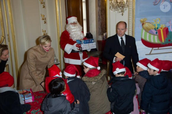 La princesse Charlene et le prince Albert II de Monaco étaient ravis de distribuer des cadeaux lors de la fête de Noël annuelle pour les enfants monégasques au palais princier, le 12 décembre 2012.