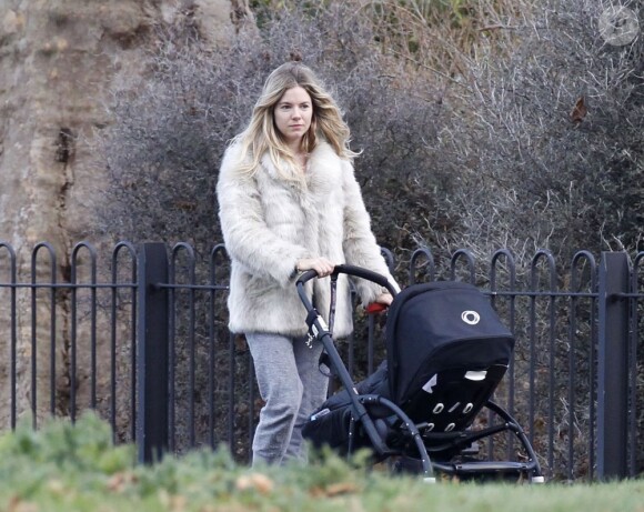 L'Anglaise Sienna Miller et sa fille Marlowe en balade dans un parc de Londres, décembre 2012.