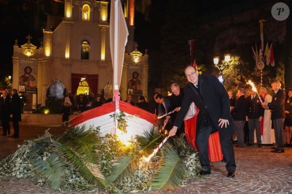 Le prince Albert II de Monaco mettant le feu à une barque symbolique sur le Quai Albert Ier dans le cadre des célébrations de Sainte-Dévote, le 26 janvier 2013.