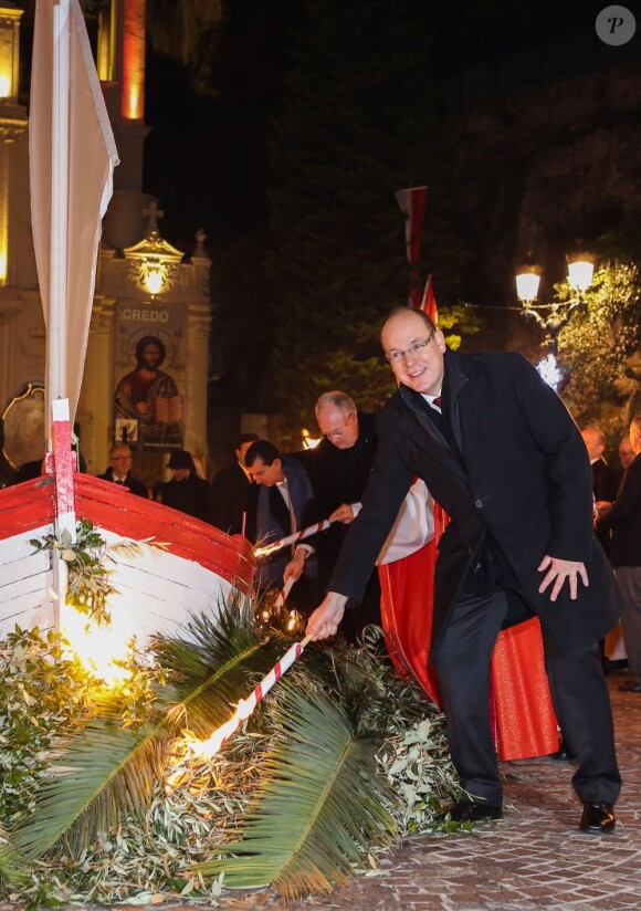 Le prince Albert II de Monaco mettant le feu à une barque symbolique sur le Quai Albert Ier dans le cadre des célébrations de Sainte-Dévote, le 26 janvier 2013.
