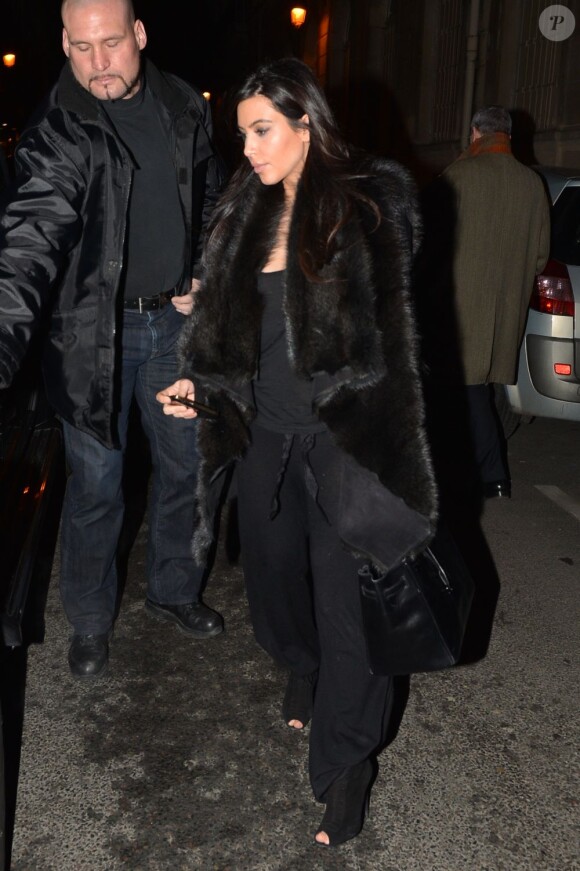 Kim Kardashian porte un épais gilet en fourrure Rick Owens, un sac Hermès et des bottines Tom Ford à la sortie du restaurant Findi. Paris, le 23 janvier 2013.