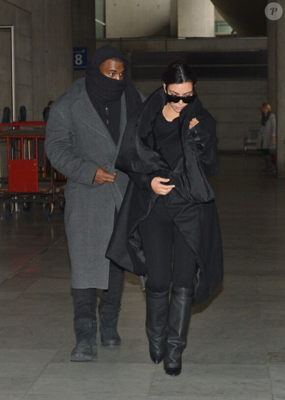 Kim Kardashian arrive incognito avec Kanye West à l'aéroport Roissy-Charles de Gaulle en provenance de Venise, habillée d'un long manteau noir et de bottes Givenchy. Le 10 janvier 2013.