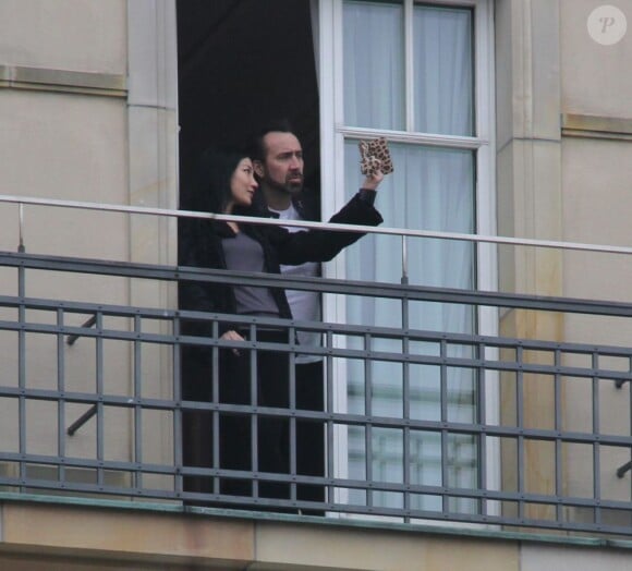 Alice Kim fume une cigarette au balcon de son hôtel, avec son mari Nicolas Cage, le 16 février 2013, en Allemagne.