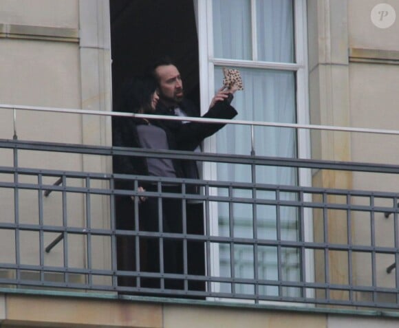 Alice Kim fume une cigarette au balcon de son hôtel, avec son époux Nicolas Cage, le 16 février 2013, en Allemagne.