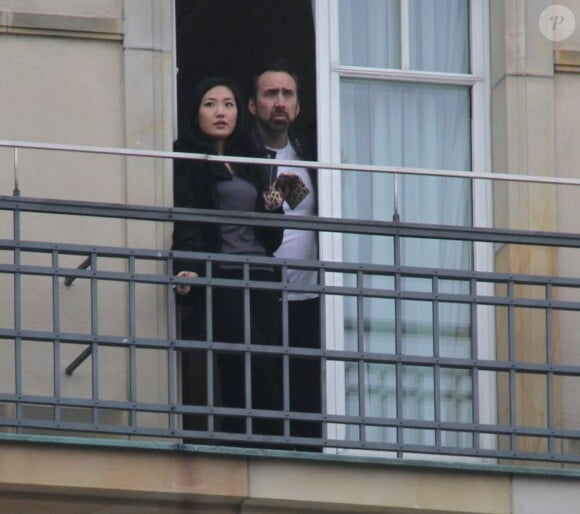 Alice Kim fume une cigarette sur le balcon de son hôtel, avec son mari Nicolas Cage, le 16 février 2013, en Allemagne.