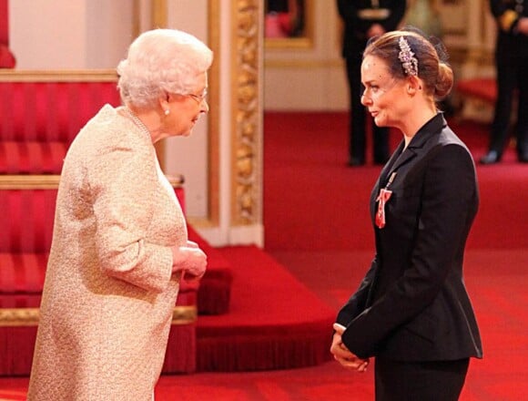 Elizabeth II remettant à Stella McCartney les insignes d'officier de l'ordre de l'empire britannique le 26 mars 2013 à Buckingham.