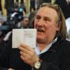 Gérard Depardieu montre fièrement son passeport de citoyen Russe lors de sa visite à Saransk, le 23 février 2013.