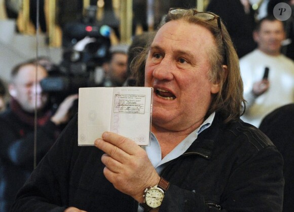 Gérard Depardieu montre fièrement son passeport de citoyen Russe lors de sa visite à Saransk, le 23 février 2013.
