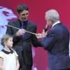 Christophe Soumillon reçoit sa Cravache d'Or des mains de Yves Saint-Martin sous les yeux de sa fille Charlie lors de la 64e cérémonie des Cravaches d'Or au Théâtre des Champs-Elysées à Paris le 3 avril 2013.