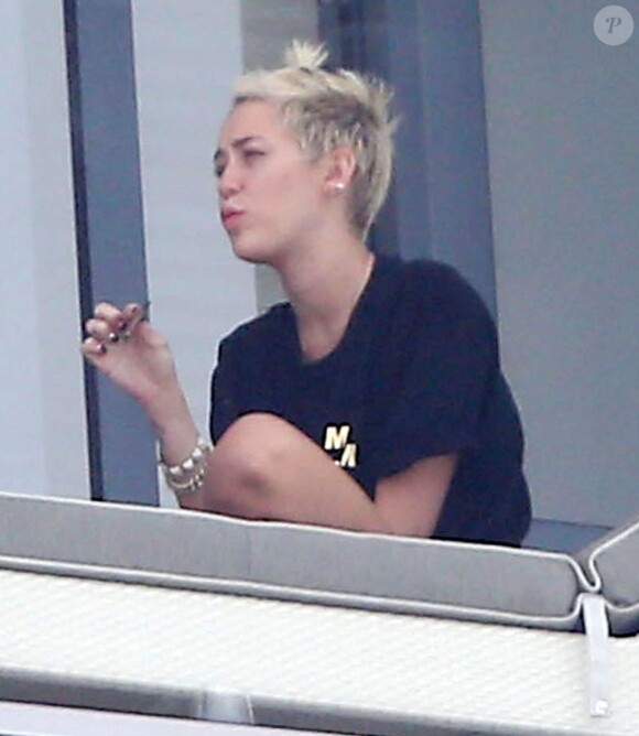 Miley Cyrus en train de fumer avec des amis sur le balcon de son hôtel à Miami le 6 avril 2013.