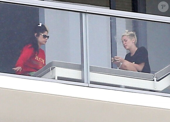 Miley Cyrus fume avec des amis sur le balcon de son hôtel à Miami le 6 avril 2013.