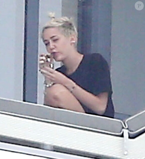 Miley Cyrus avec des amis sur le balcon de son hôtel à Miami le 6 avril 2013.