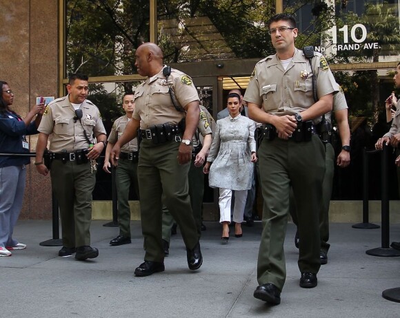 Kim Kardashian, enceinte, escortée par de nombreux policiers, à la sortie du tribunal Stanley Mosk de Los Angeles dans le cadre de la procédure de divorce avec Kris Humphries, le 12 avril 2013