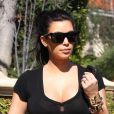 Kim Kardashian, tout de noir vêtue avec un pantalon en cuir J Brand, une chemise Pyrex nouée à la taille, un sac Balenciaga et des bottines Azzedine Alaïa Los Angeles. Le 12 février 2013.