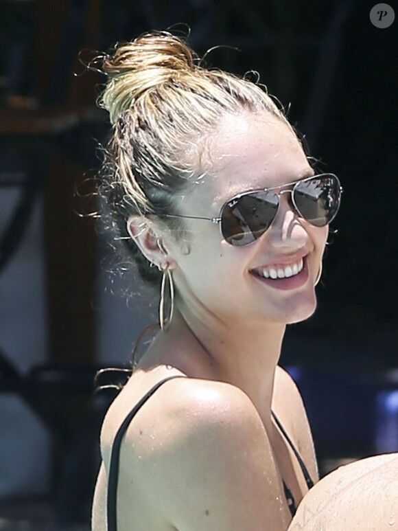 Le mannequin Candice Swanepoel, tout sourire, se détend au bord d'une piscine à Miami, le 25 mai 2013.