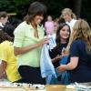 Michelle Obama, toujours aussi souriante, récolte les légumes du potager de la Maison Blanche en compagnie d'enfants originaires du New Jersey qui ont été touchés par l'ouragan Sandy, et ceux qui ont planté les légumes au mois d'avril. Washington, le 28 mai 2013.