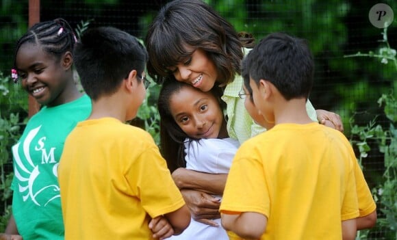 La First Lady Michelle Obama récolte les légumes du potager de la Maison Blanche en compagnie d'enfants originaires du New Jersey qui ont été touchés par l'ouragan Sandy, et ceux qui ont planté les légumes au mois d'avril. Washington, le 28 mai 2013.