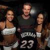 David Beckham, tout heureux au milieu de deux cheerleaders du Heat de Miami, reçoit un maillot à son nom du Heat, lors d'une soirée au Hyde de l'American Airlines Arena après la victoire des locaux face aux Pacers de l'Indiana, le 30 mai 2013, lors du match 5 de la finale de conférence (90-79)