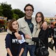 Anthony Delon avec ses filles Lou et Liv lors de l'inauguration de la fête foraine des Tuileries à Paris le 28 juin 2013