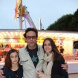 Anthony Delon avec ses filles Lou et Liv lors de l'inauguration de la fête foraine des Tuileries à Paris le 28 juin 2013