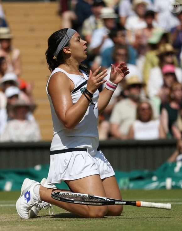 Marion Bartoli, à genoux après un dernier ace, remporte le tournoi de Wimbledon face à l'Allemande Sabine Lisicki. Londres, le 6 juillet 2013.