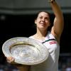 Marion Bartoli salue le public avec son son trophée en main. Londres, le 6 juillet 2013.