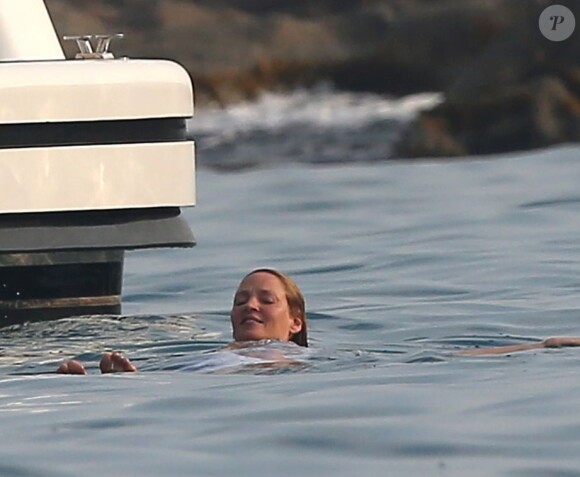 Uma Thurman se baigne dans la mer près d'un yacht à Saint-Tropez, le 14 juillet 2013.
