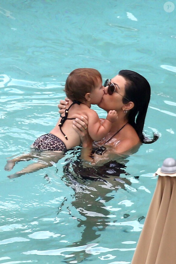 Kourtney Kardashian couvre sa fille Penelope de papouilles lors d'une baignade dans une piscine de l'hôtel Setai. Miami, le 21 juillet 2013.