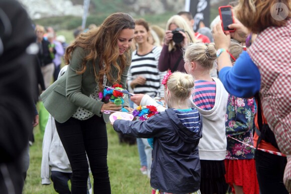 Kate Middleton (en top Zara et veste Ralph Lauren) a accompagné le prince William le 30 août 2013 au départ de l'Ultra Marathon Ring O'Fire d'Anglesey, effectuant ainsi sa première apparition publique depuis la naissance de leur fils le prince George.
