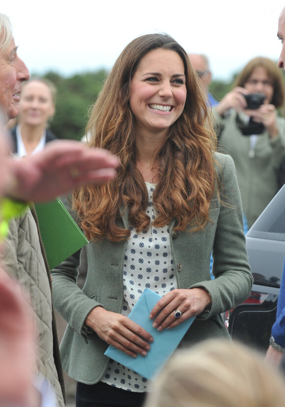 Kate Middleton (en top Zara et veste Ralph Lauren) a accompagné le prince William le 30 août 2013 au départ de l'Ultra Marathon Ring O'Fire d'Anglesey, effectuant ainsi sa première apparition publique depuis la naissance de leur fils le prince George.
