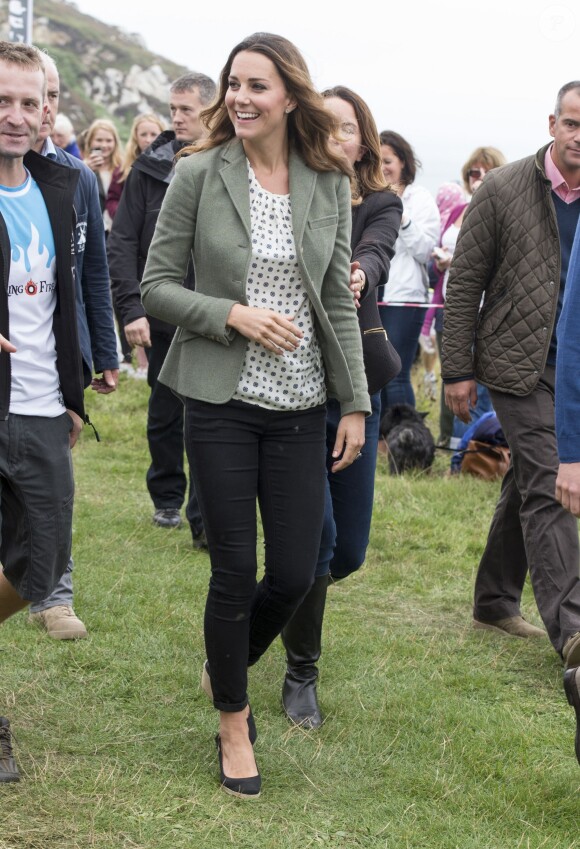 Kate Middleton, par surprise, était présente (et mince) au côté de son mari le prince William le 30 août 2013 au départ de l'Ultra Marathon Ring O'Fire d'Anglesey, effectuant ainsi sa première apparition publique depuis la naissance de leur fils le prince George.