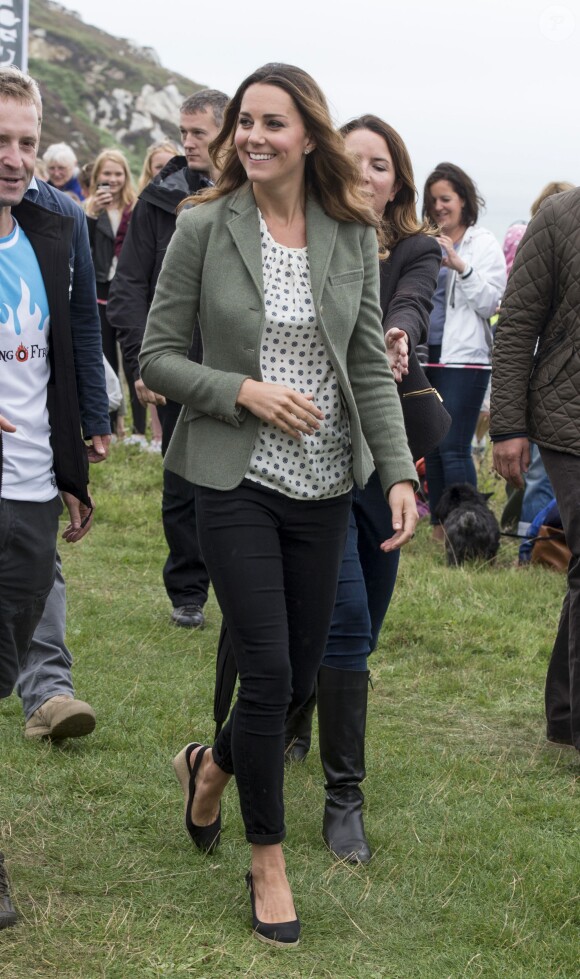 Kate Middleton, par surprise, était présente (et mince) au côté de son mari le prince William le 30 août 2013 au départ de l'Ultra Marathon Ring O'Fire d'Anglesey, effectuant ainsi sa première apparition publique depuis la naissance de leur fils le prince George.