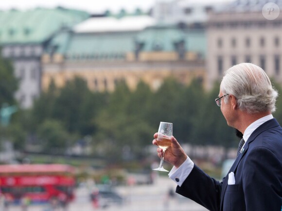 Le roi Carl XVI Gustaf de Suède boit à la santé de ses compatriotes et lève son verre à ses 40 ans de règne, le 15 septembre 2013 au balcon du palais royal, à Stockholm.
