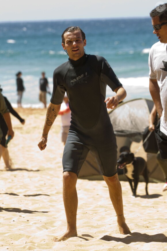 Louis Tomlinson du groupe One Direction fait du surf sur une plage de Sydney, le 7 octobre 2013.