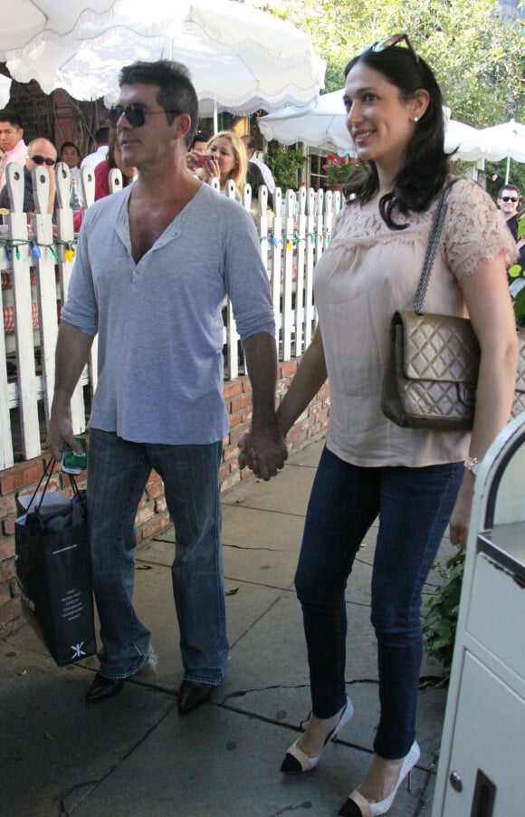 Simon Cowell et sa compagne Lauren Silverman (enceinte) sortent du restaurant The Ivy à Los Angeles, le 12 octobre 2013.
