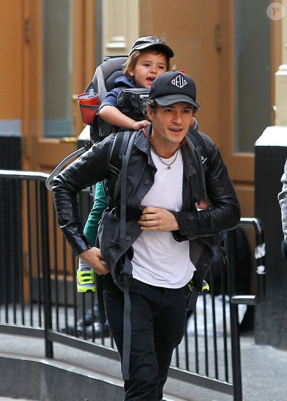 L'acteur anglais Orlando Bloom porte son fils Flynn sur le dos alors qu'il se promène à New York, le 14 octobre 2013.