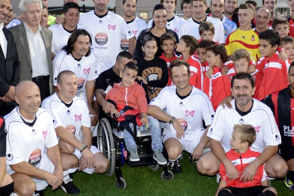 David Hallyday au côté du petit Yanis en compagnie d'Olivier Panis et Frédéric Meyrieu, lors d'un match de foot caritatif pour récolter des fonds pour l'association Pour Yanis, le 24 octobre 2013 à La Ciotat