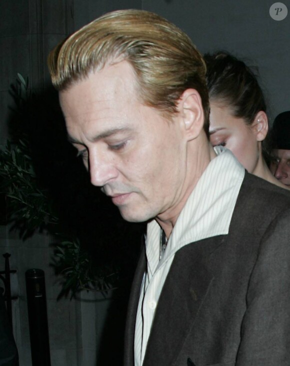 L'acteur américain Johnny Depp, teint en blond, et sa petite amie Amber Heard sortent du restaurant Ronnie Scott à Londres, le 25 Octobre 2013.