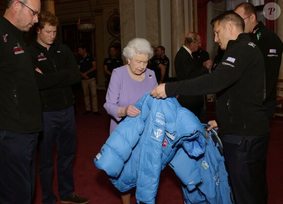 La reine Elizabeth II découvre l'équipement du prince Harry et des membres de l'association Walking with the Wounded avant de voir ces derniers s'envoler pour le pôle Sud, le 13 novembre 2013 à Buckingham Palace