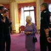 Le prince Harry et les membres de l'association Walking with the Wounded présentent à la reine Elizabeth II leur équipement avant de s'envoler pour le pôle Sud, le 13 novembre 2013 à Buckingham Palace