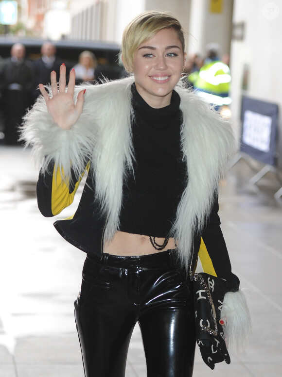 Miley Cyrus signe des autographes et pose avec ses fans devant les studios de la BBC Radio 1 à Londres. Le 12 novembre 2013.