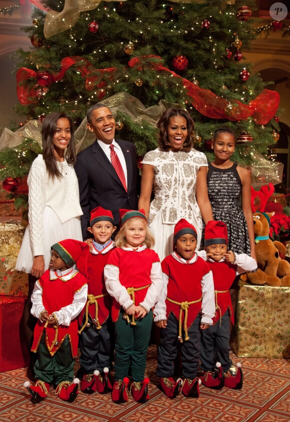 Barack, Michelle, Sasha et Malia Obama posent avec les lutins du père Noël lors de l'enregistrement de l'émission Christmas in Washington au National Building Museum. Washington, le 15 décembre 2013.
