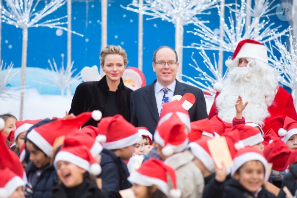 Le prince Albert II de Monaco et la princesse Charlene radieux lors du goûter de Noël des enfants monégasques dans la cour du palais princier le 18 décembre 2013
