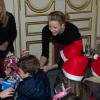 La princesse Charlene de Monaco en pleine distribution de cadeaux lors du goûter de Noël des enfants monégasques le 18 décembre 2013 au palais princier.