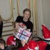 La princesse Charlene de Monaco en pleine distribution de cadeaux lors du goûter de Noël des enfants monégasques le 18 décembre 2013 au palais princier.